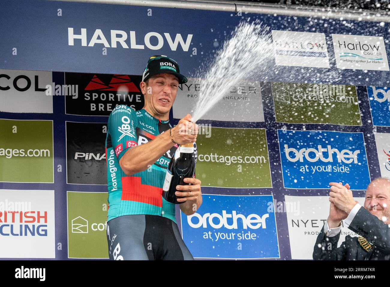 Winner Danny van Poppel celebrating at the Tour of Britain cycle race Stage 6 at the finish in Harlow, Essex, UK. Spraying champagne on podium Stock Photo