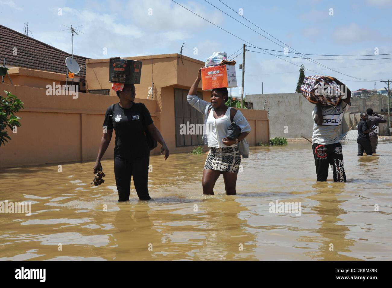 221006 -- ACCRA, Oct. 6, 2022 -- People wade through a flooded street in Accra, Ghana, on Oct. 5, 2022. Thousands of residents of the southwestern part of Accra, the Ghanaian capital, have been displaced due to the spillage of the Weija Dam. The spillage of the dam was caused by excess water following torrential rains over the weekend, which contributed to the water level behind the dam rising above the maximum level. The dam built on the Densu River is the source of potable water for more than half of the 5.4 million population of the national capital. Photo by /Xinhua GHANA-ACCRA-DAM SPILLAG Stock Photo