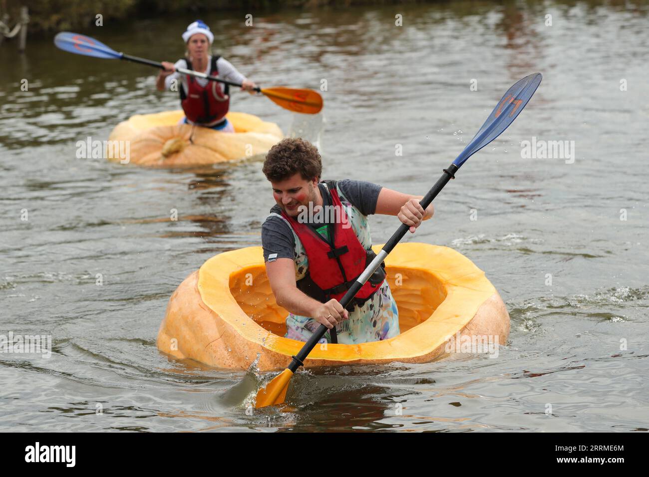 221024 -- KASTERLEE, Oct. 24, 2022 -- People compete in the pumpkin regatta in the village of Lichtaart of Kasterlee, Belgium, Oct. 23, 2022. The 13th edition of pumpkin regatta is a kayaking competition in Belgium, attracting participants to sit and compete in large hollow-out pumpkins. According to local organizers, the weight of each pumpkin that was made into a boat could reach hundreds of kilograms.  BELGIUM-KASTERLEE-PUMPKIN REGATTA ZhengxHuansong PUBLICATIONxNOTxINxCHN Stock Photo