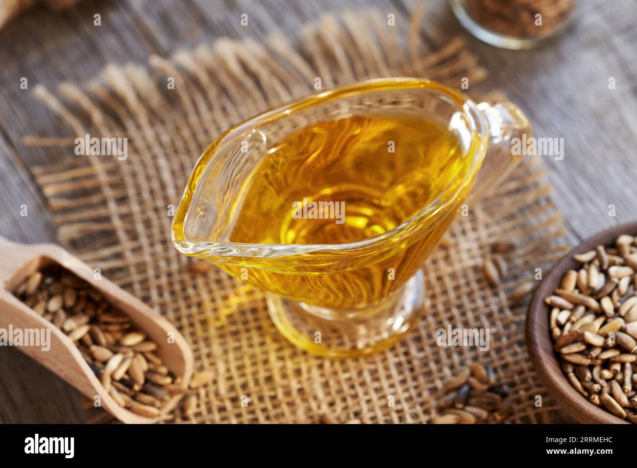 A jug of milk thistle oil, with Carduus marianus seeds in the background Stock Photo