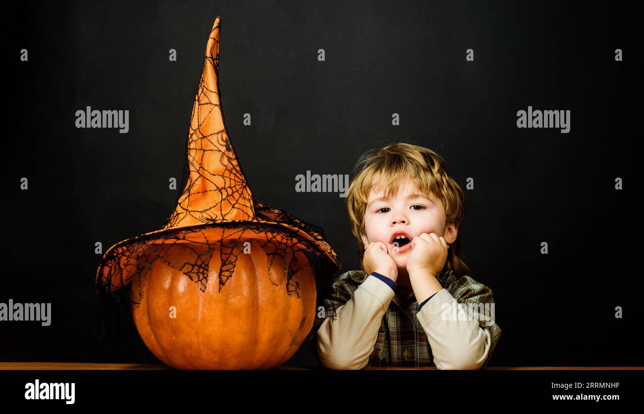 Preparation for Halloween holidays. Surprised kid boy with halloween jack-o-lantern. Cute Halloween child with pumpkin. Autumn recipes. Thanksgiving Stock Photo