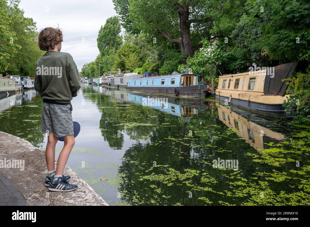 Boy looking at canal boats in Little Venice, London Stock Photo