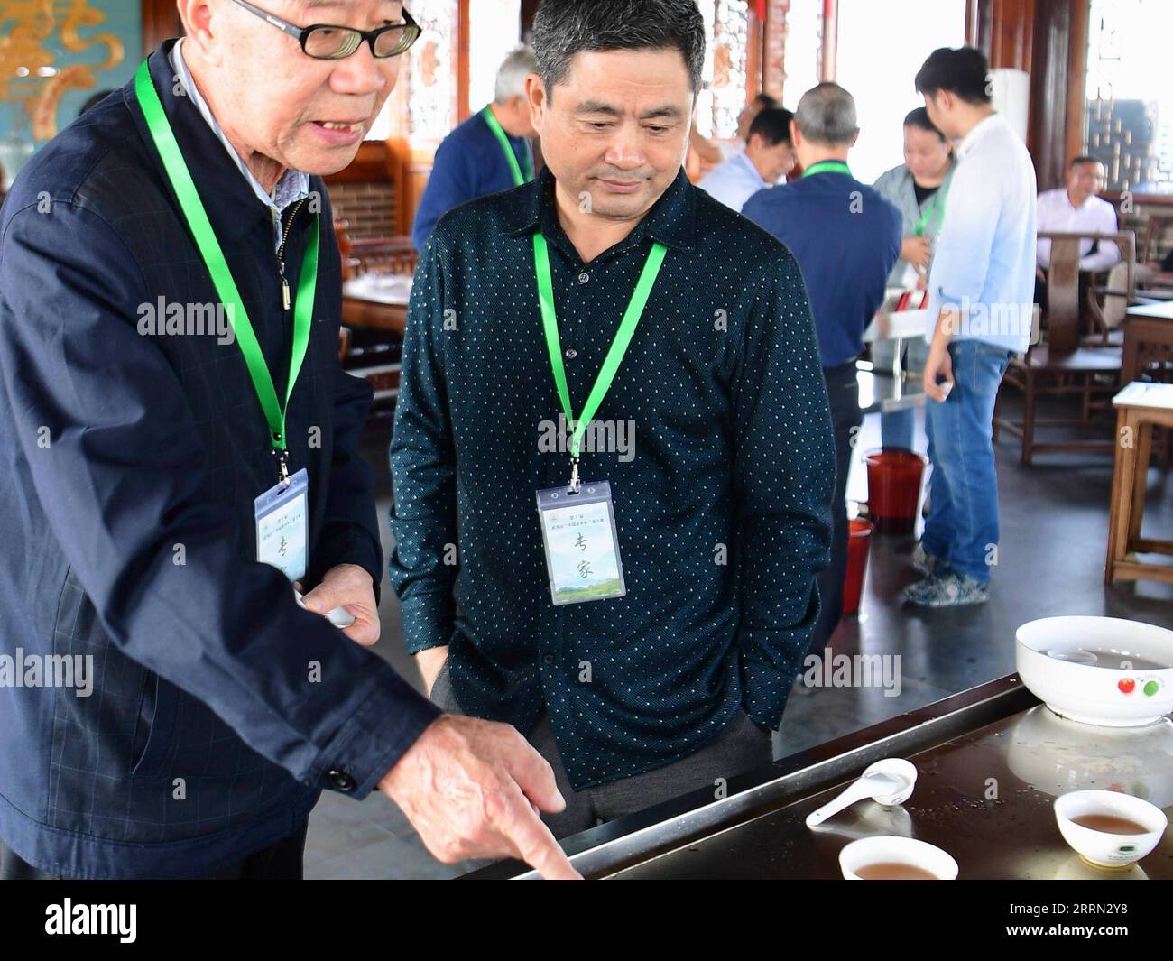 221202 -- WUYISHAN, Dec. 2, 2022 -- Ye Qitong 1st L, a national inheritor of Wuyi rock tea making technique, comments on tea at a tea tasting competition in Wuyishan, southeast China s Fujian Province, Oct. 28, 2017. Wuyishan, the hometown of rock tea, boasts a wide range of rock tea varieties. The making technique of Wuyi rock tea, a special oolong variety with a particularly roasted taste and floral and fruity aroma, is comprised of more than 10 processing procedures including tea harvesting, withering, fixation, twisting, drying and so on. Inherited and developed with a long history, the ma Stock Photo