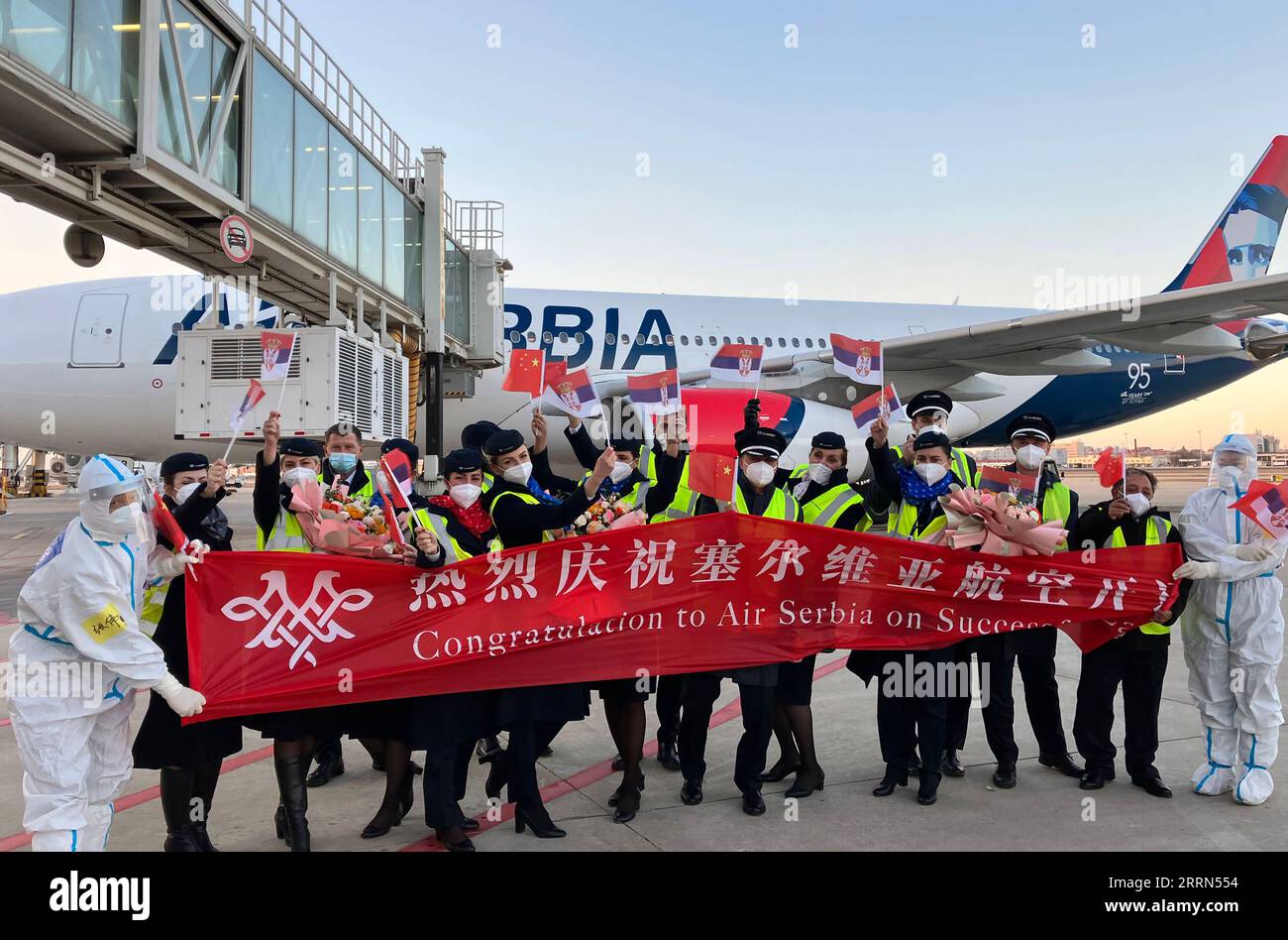 221210 -- TIANJIN, Dec. 10, 2022 -- Airport staff members and crew members of flight JU702 pose for a group photo at Tianjin Binhai International Airport in north China s Tianjin, Dec. 10, 2022. The flight carrying about 170 passengers landed at Tianjin Binhai International Airport on Saturday, marking the official opening of the direct flight between Serbia s Belgrade and north China s Tianjin city. Flights operated by Serbia s national carrier Air Serbia, will run once a week.  CHINA-TIANJIN-DIRECT FLIGHT-BELGRADE-TIANJIN-LANDING CN LixRan PUBLICATIONxNOTxINxCHN Stock Photo