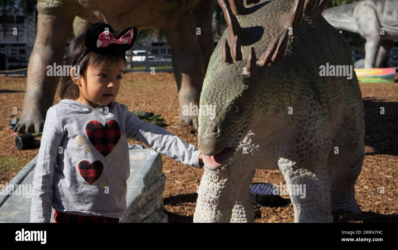 221219 WOODLAND HILLS U S - 221219 Woodland Hills Us Dec 19 2022 A Girl Touches A Life Sized Dinosaur At An Exhibition Named Dinosaurs In The Valley In Woodland Hills California The United States On Dec 18 2022 A Large Scale Dinosaur Exhibition Is Being Held In Woodland Hills In Southern California Attracting Visitors To Interact With Life Sized Animated Dinosaurs Photo By Xinhua Us California Woodland Hills Dinosaur Exhibition Zengxhui Publicationxnotxinxchn 2RRN7HC 