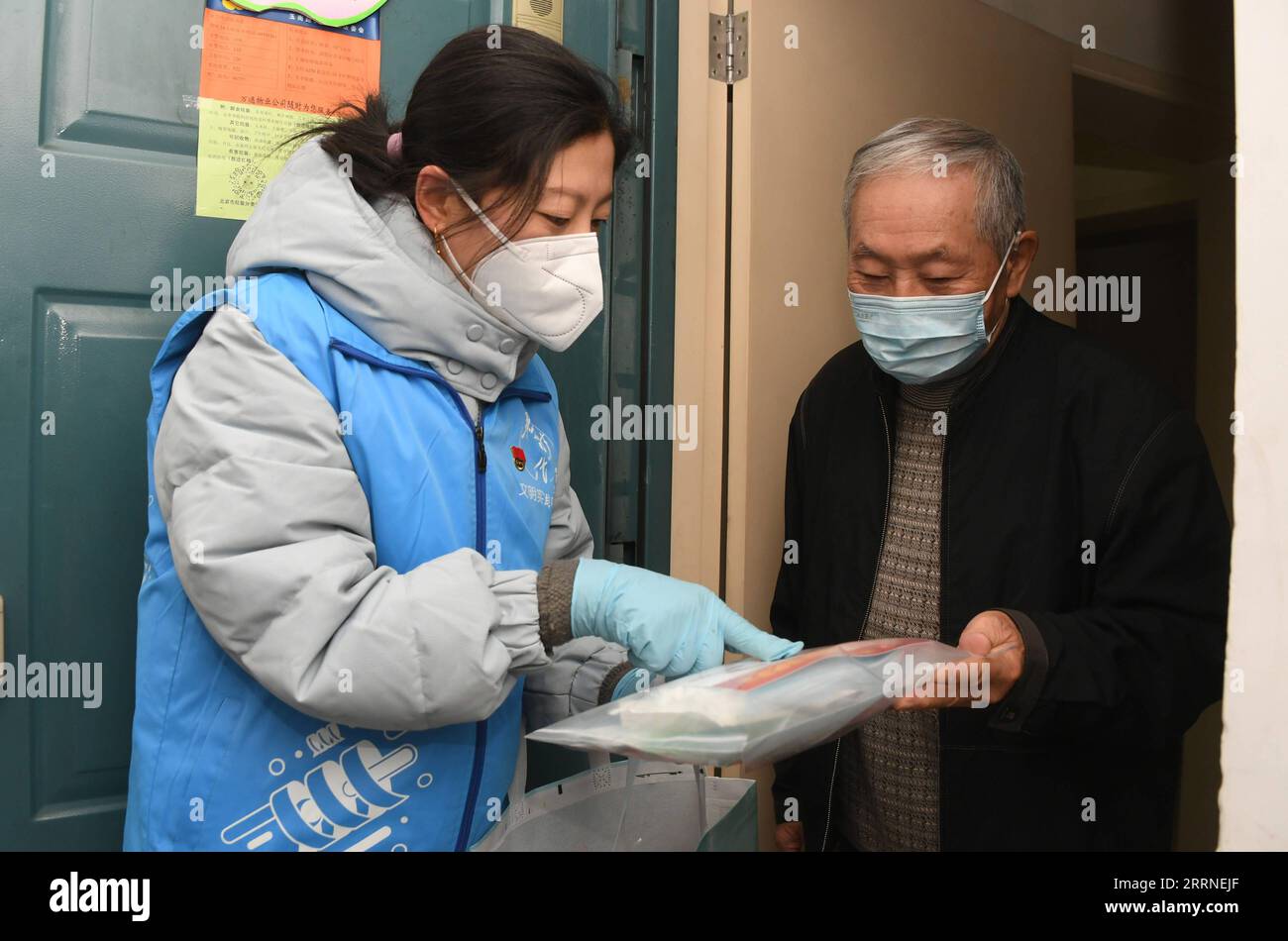 230107 -- BEIJING, Jan. 7, 2023 -- A community worker L explains a COVID-19 prevention and care package to a resident in Yangfangdian Subdistrict of Haidian District in Beijing, capital of China, Dec. 27, 2022.  Xinhua Headlines: Six fallacies and truths about China s epidemic control RenxChao PUBLICATIONxNOTxINxCHN Stock Photo