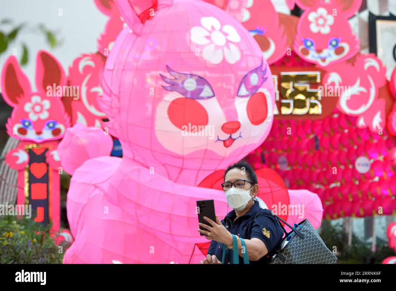 230118 -- BANGKOK, Jan. 18, 2023 -- A woman takes a selfie with decorations for the upcoming Lunar New Year in front of a shopping mall in Bangkok, Thailand on Jan. 18, 2023. Rachen Sageamsak THAILAND-BANGKOK-LUNAR NEW YEAR-DECORATIONS LaxHeng PUBLICATIONxNOTxINxCHN Stock Photo