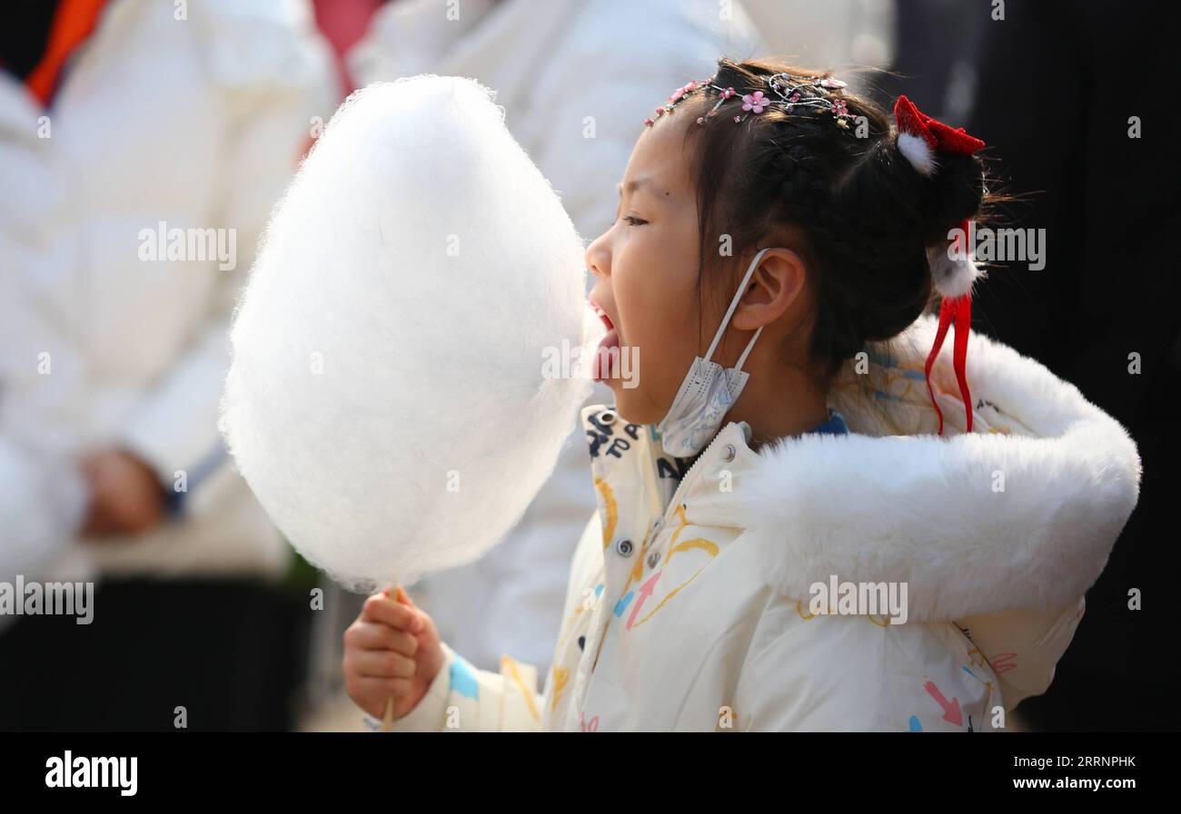 230124 -- TENGZHOU, Jan. 24, 2023 -- A girl eats cotton candy in Xigang Township of Tengzhou, east China s Shandong Province, Jan. 22, 2023. People enjoy various kinds of cuisine in China during the Spring Festival holiday. Photo by /Xinhua CHINA-SPRING FESTIVAL-CUISINE CN LixZhijun PUBLICATIONxNOTxINxCHN Stock Photo