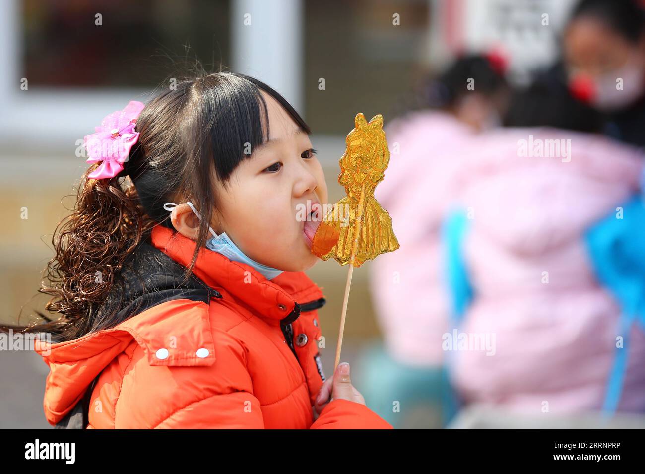 230124 -- TENGZHOU, Jan. 24, 2023 -- A girl tastes sugar painting in Xigang Township of Tengzhou, east China s Shandong Province, Jan. 22, 2023. People enjoy various kinds of cuisine in China during the Spring Festival holiday. Photo by /Xinhua CHINA-SPRING FESTIVAL-CUISINE CN LixZhijun PUBLICATIONxNOTxINxCHN Stock Photo