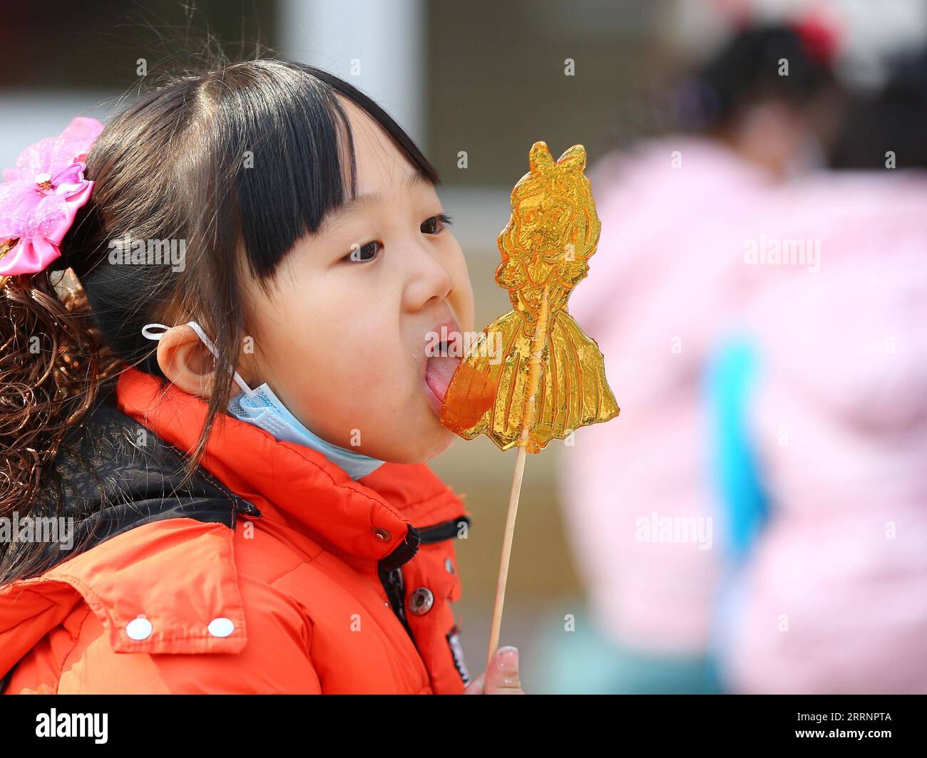 230124 -- TENGZHOU, Jan. 24, 2023 -- A girl tastes sugar painting in Xigang Township of Tengzhou, east China s Shandong Province, Jan. 22, 2023. People enjoy various kinds of cuisine in China during the Spring Festival holiday. Photo by /Xinhua CHINA-SPRING FESTIVAL-CUISINE CN LixZhijun PUBLICATIONxNOTxINxCHN Stock Photo