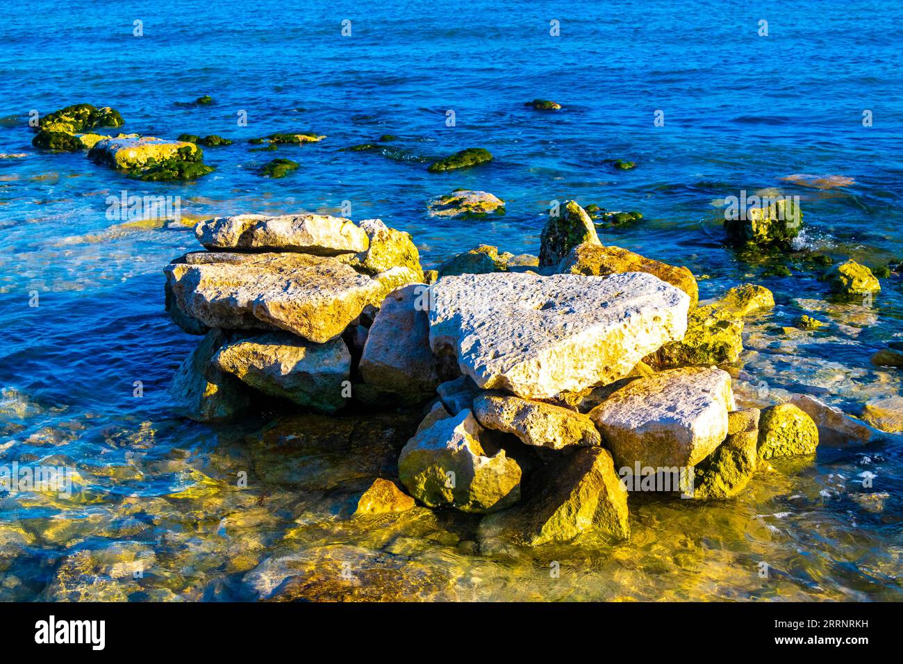 Stones rocks and corals in turquoise green and blue water on the beach ...