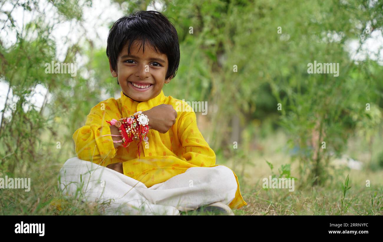 Hindu Brother and sister in ethnic wear holding Indian sweets and gift