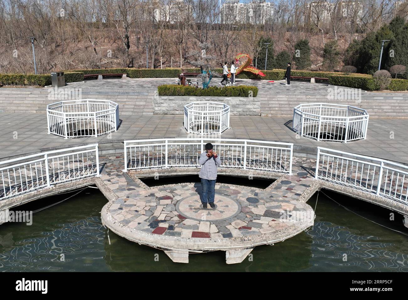 230221 -- XINGTAI, Feb. 21, 2023 -- This aerial photo shows Hou Yimin playing the ocarina in a park in Xingtai, north China s Hebei Province, Feb. 20, 2023. Ocarina is a small sized, flute-like musical instrument, which has gained popularity around the world in recent years. Hou Yimin, a craftsman from Xingtai, Hebei Province, has been working on the research and production of wooden ocarinas since 2003. So far, Hou has made about 5,000 wooden ocarinas of over a hundred different types, selling to many countries including the United States, Japan, and South Korea. Some of his ocarinas are of t Stock Photo