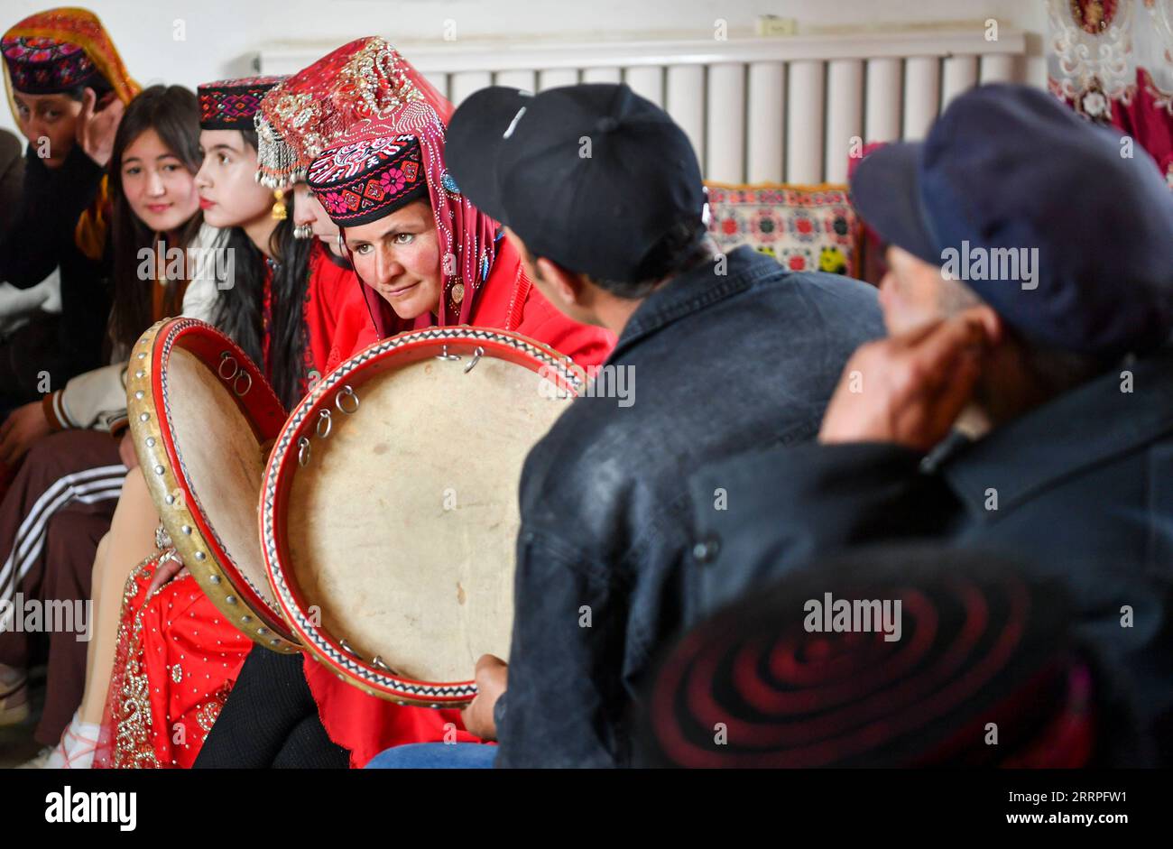 230322 -- TAXKORGAN, March 22, 2023 -- Relatives and friends of the bride Gulihan Jrbli play tambourines and sing at her home in Taxkorgan Tajik Autonomous County, northwest China s Xinjiang Uygur Autonomous Region, March 18, 2023. In Taxkorgan Tajik Autonomous County, many young men and women prefer to get married in the spring season. Recently in Fumin Village, 25-year-old Gulihan Jrbli and her groom Mairmaitih Tirmur held a wedding after falling in love for more than three years. The ceremony was conducted according to traditional Tajik wedding custom, with relatives, friends and villagers Stock Photo