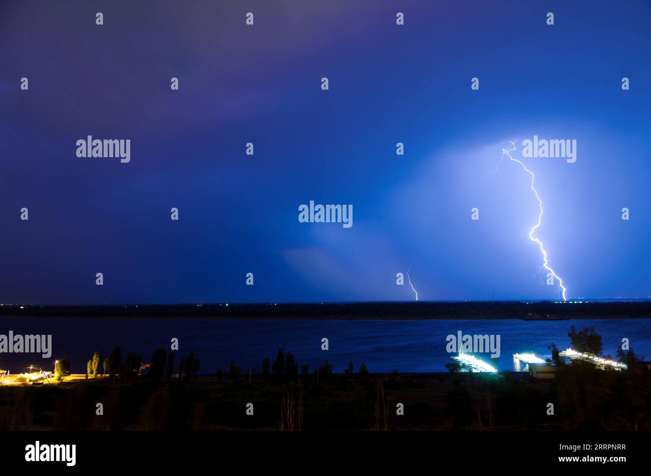 Lightning over night river in the blue sky Stock Photo - Alamy