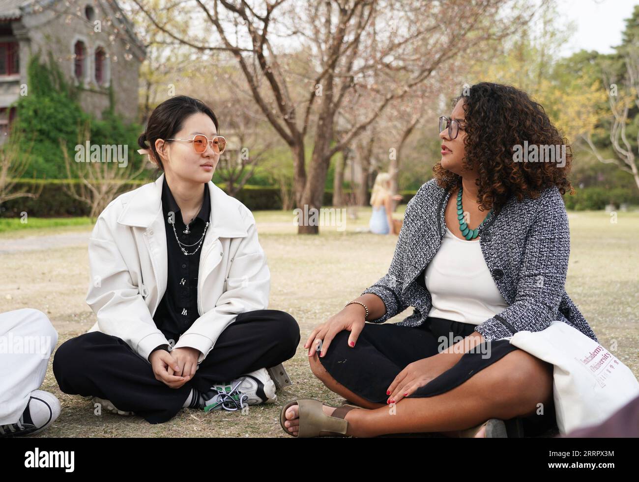 230415 -- BEIJING, April 15, 2023 -- Rafaela R chats with a schoolmate at Peking University in Beijing, capital of China, March 31, 2023. Maria Eduarda Variani, Rafaela Viana dos Santos, Manuela Boiteux Pestana, and Marco Andre Rocha Germano are Brazilian students studying in the Master of China Studies program at the Yenching Academy of Peking University in China. The four of them have been interested in Chinese culture since they were young. After arriving in Beijing, they have been impressed by the Chinese capital s profound cultural heritage, convenient public services, and fabulous citysc Stock Photo