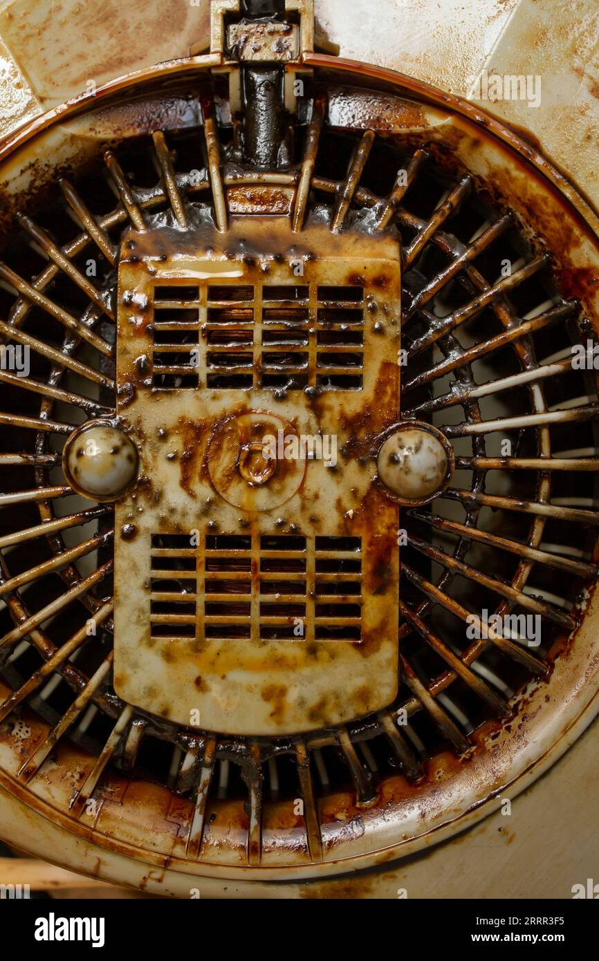 Dirty with burned grease cooker hood filter fan motor, soft focus close