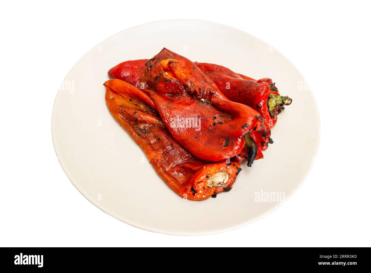 grilled roasted and peeled red peppers on a ceramic plate isolated on white background Stock Photo