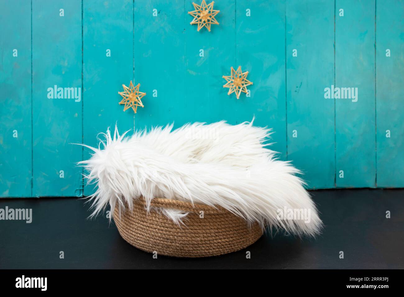 New born or baby portrait photography backdrop with white fur, straw snowflakes, jute rope basket and blue painted wood boards Stock Photo
