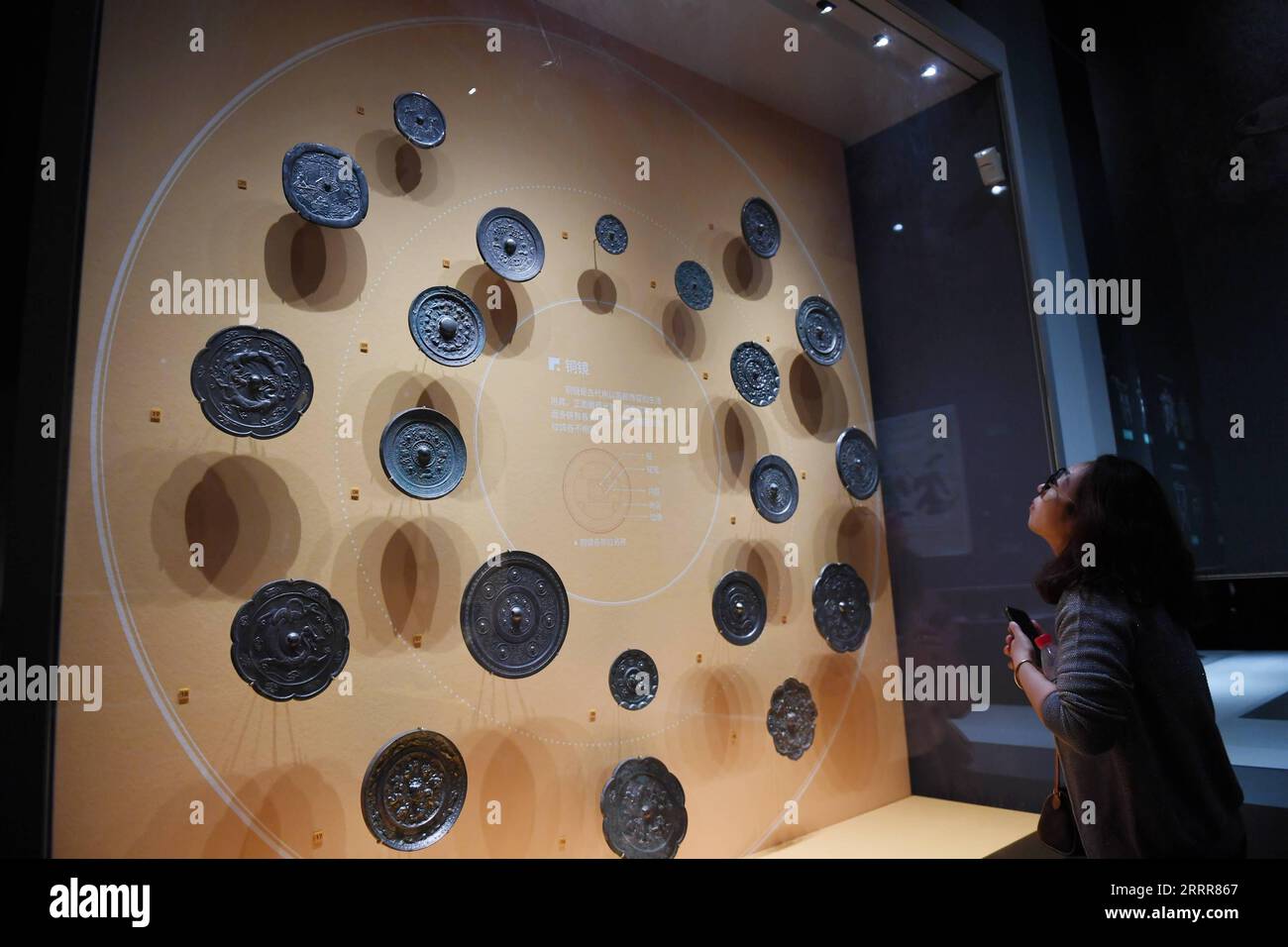 230513 -- XI AN, May 13, 2023 -- A visitor views bronze mirrors displayed at Xi an Museum in Xi an, northwest China s Shaanxi Province, May 8, 2023. Founded about 3,100 years ago, Xi an, which is today the capital of China s Shaanxi Province, served as the capital for 13 dynasties in Chinese history. This is also the place where Zhang Qian, an envoy of the Western Han Dynasty 202 BC-25 AD, began his journey to the Western regions via Central Asia. This expedition eventually led to the opening of the Silk Road. Xi an has a total of 159 museums, attracting over 30 million people each year. Many Stock Photo