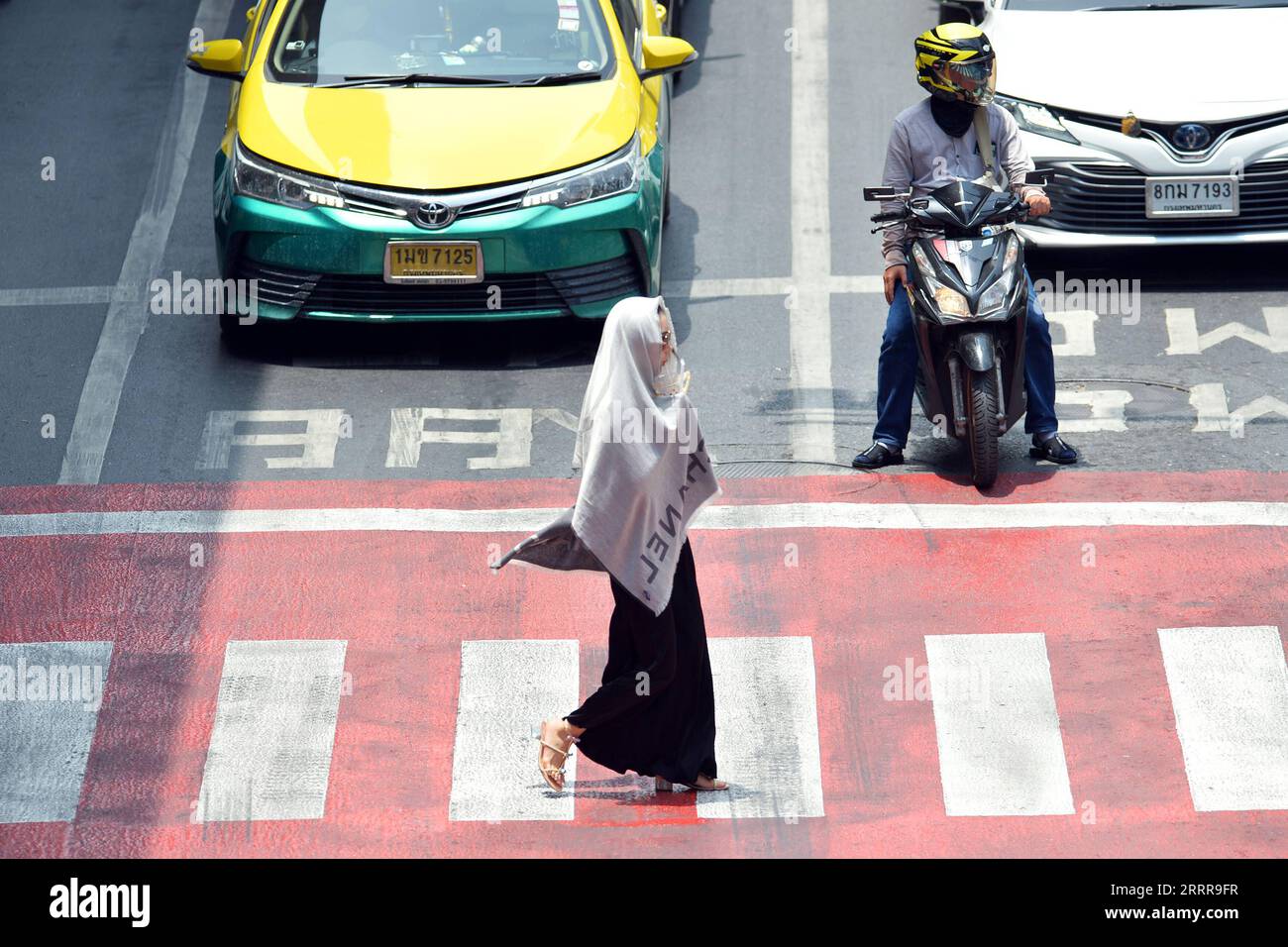 230517 -- BANGKOK, May 17, 2023 -- A pedestrian shades herself from sunshine with a scarf in Bangkok, Thailand, May 17, 2023. Thailand is hit by a heat wave, with the highest temperature in Bangkok reaching 41 degrees Celsius recently. Rachen Sageamsak THAILAND-BANGKOK-HEATWAVE LaxHeng PUBLICATIONxNOTxINxCHN Stock Photo