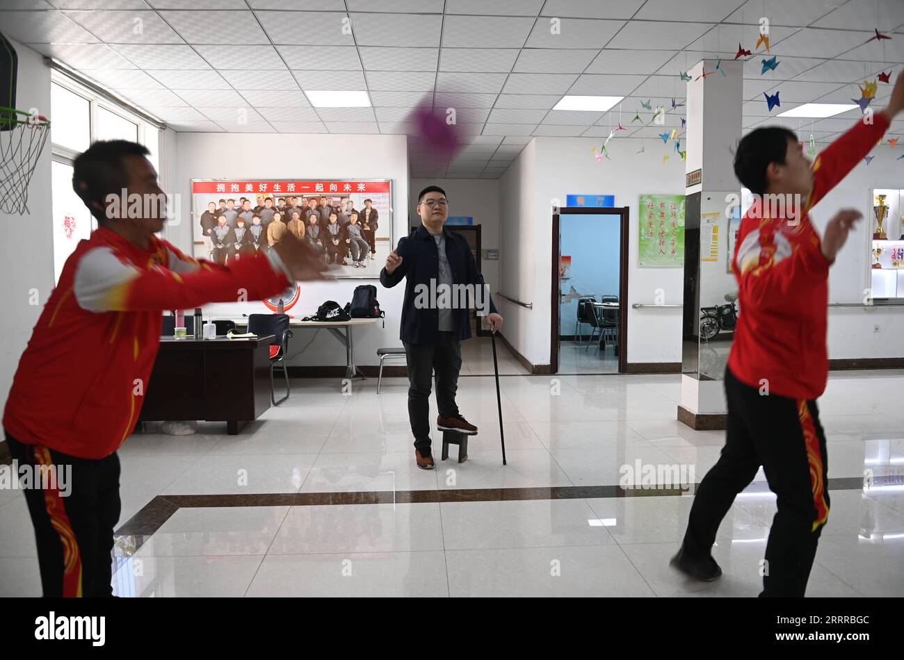 230521 -- SHENYANG, May 21, 2023 -- Zhao Qiang gives guidance for the intellectually-challenged during exercise in Shenyang, northeast China s Liaoning Province, April 18, 2023. When Zhao Qiang was two years old, he developed a disease which gradually resulted a 23-centimeter disparity between two legs. He fixed a small stool on the sole of left foot at the suggestion of his family and adapted to walking with it. Zhao Qiang had to drop out early due to the disease but after hard work, he was admitted to Northeastern University, majoring in computer for continuing education. Zhao Qiang has work Stock Photo