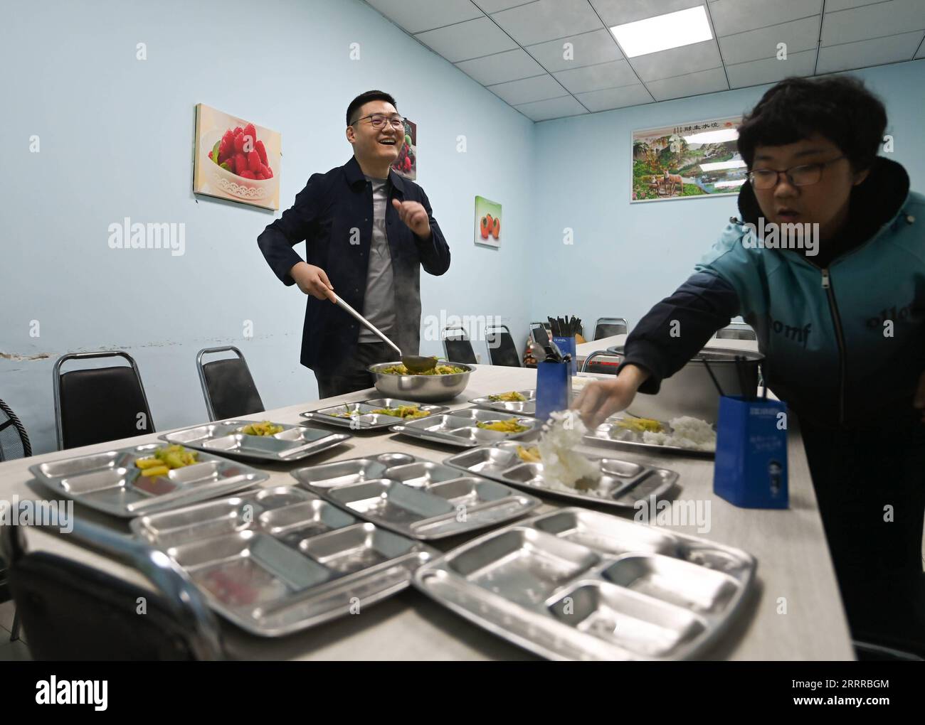 230521 -- SHENYANG, May 21, 2023 -- Zhao Qiang L prepares food for the intellectually-challenged in Shenyang, northeast China s Liaoning Province, April 18, 2023. When Zhao Qiang was two years old, he developed a disease which gradually resulted a 23-centimeter disparity between two legs. He fixed a small stool on the sole of left foot at the suggestion of his family and adapted to walking with it. Zhao Qiang had to drop out early due to the disease but after hard work, he was admitted to Northeastern University, majoring in computer for continuing education. Zhao Qiang has worked for the disa Stock Photo