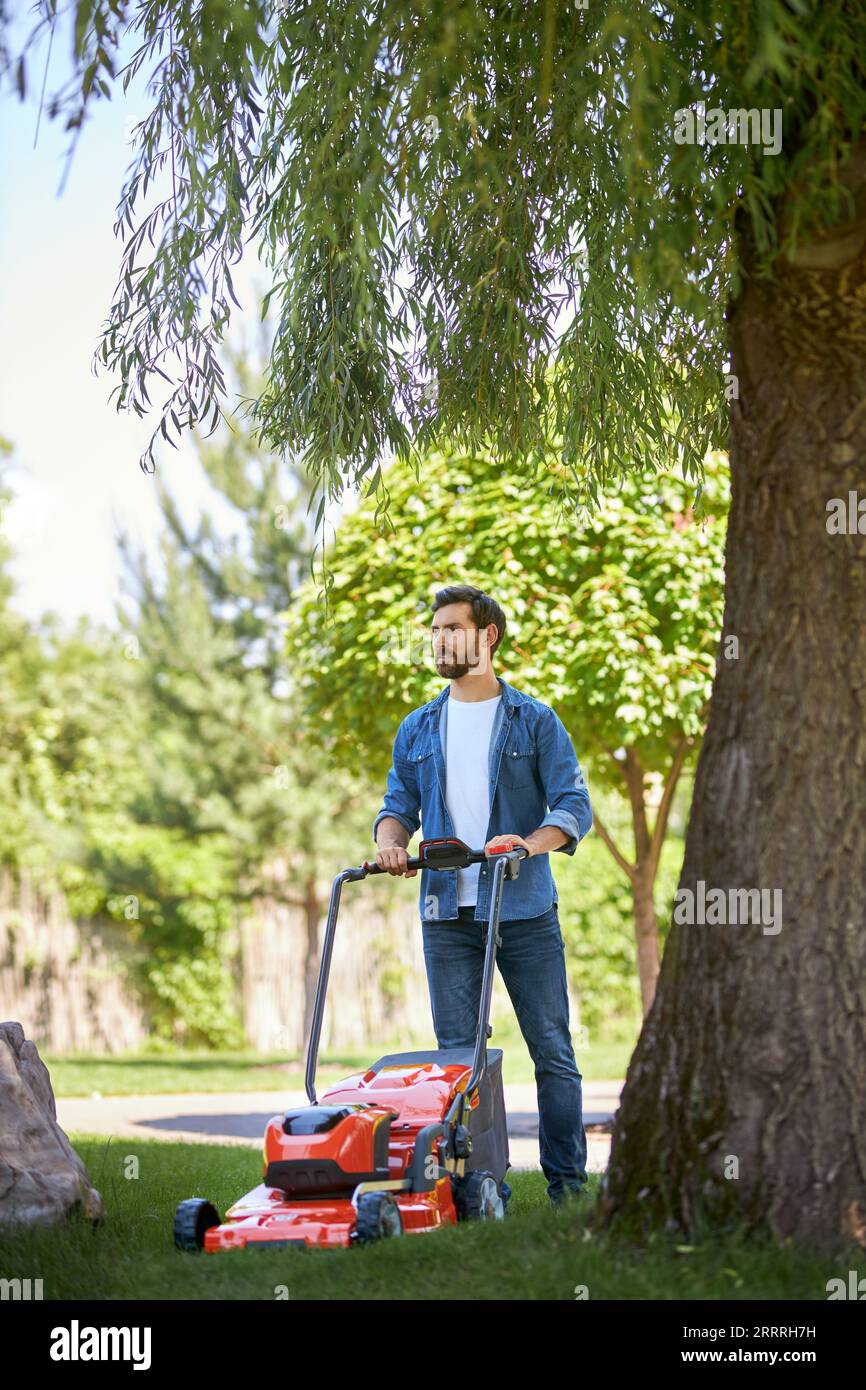 Man trimming fresh grass using brush cutter Stock Photo Alamy