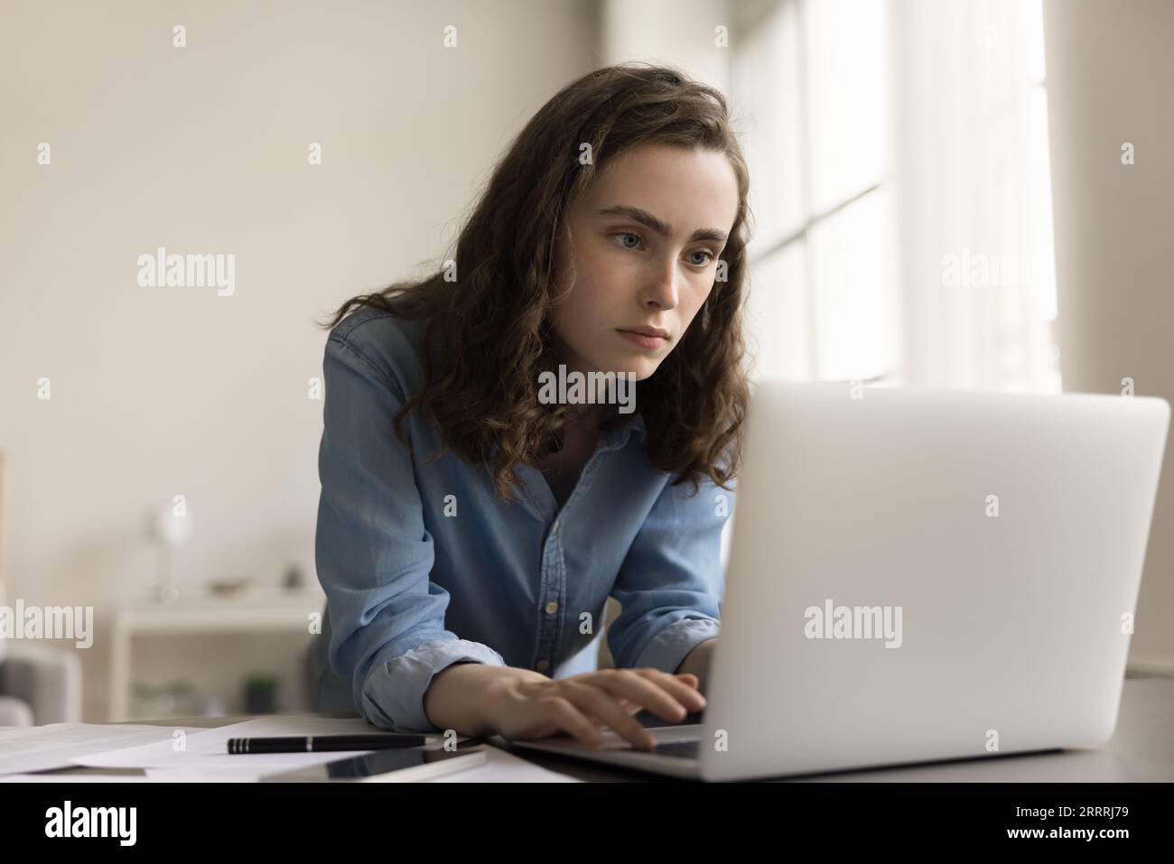 Serious young gen Z business woman typing at laptop Stock Photo - Alamy
