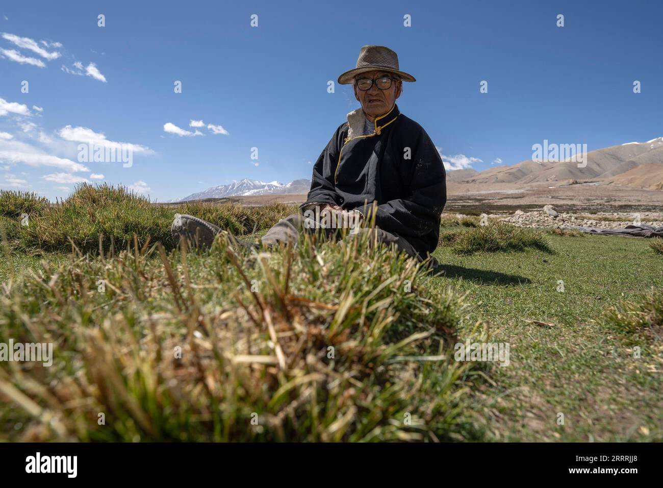 230531 -- NGARI, May 31, 2023 -- Losang Zhamdu basks at a meadow in front of his residence in Demqog Village, Zhaxigang Township, Gar County in Ngari Prefecture of southwest China s Tibet Autonomous Region, May 28, 2023. Sitting in the sun outside his residence in Demqog Village, Zhaxigang Township, Gar County in Ngari Prefecture of Tibet, 84-year-old Losang Zhamdu told a story of the five homes he had lived in. My mother and I lived together in a tent made with yak hair, all our possessions were a goat fur jacket and a worn-out Tibetan blanket, recalled Losang Zhamdu, then a serf, on his chil Stock Photo