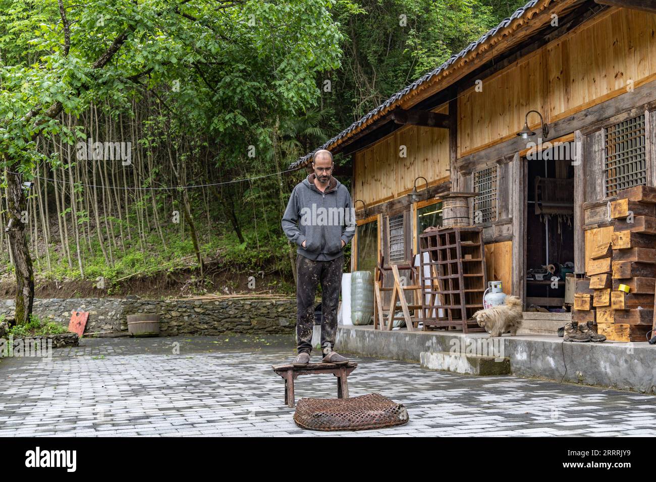 230531 -- CHONGQING, May 31, 2023 -- Vincent Cazeneuve is pictured outside his studio in Songbai Village of Beiping Town, Chengkou County, southwest China s Chongqing Municipality, May 29, 2023. Vincent Cazeneuve s studio, a two-story wooden house surrounded by lacquer trees, is located deep in the Daba Mountains in Beiping Town of Chengkou County, southwest China s Chongqing Municipality. Fascinated by lacquer art, the French artist came to China 15 years ago with the aim of finding the suitable species of lacquer tree to make lacquer artworks. He had visited many places in China, and finally Stock Photo
