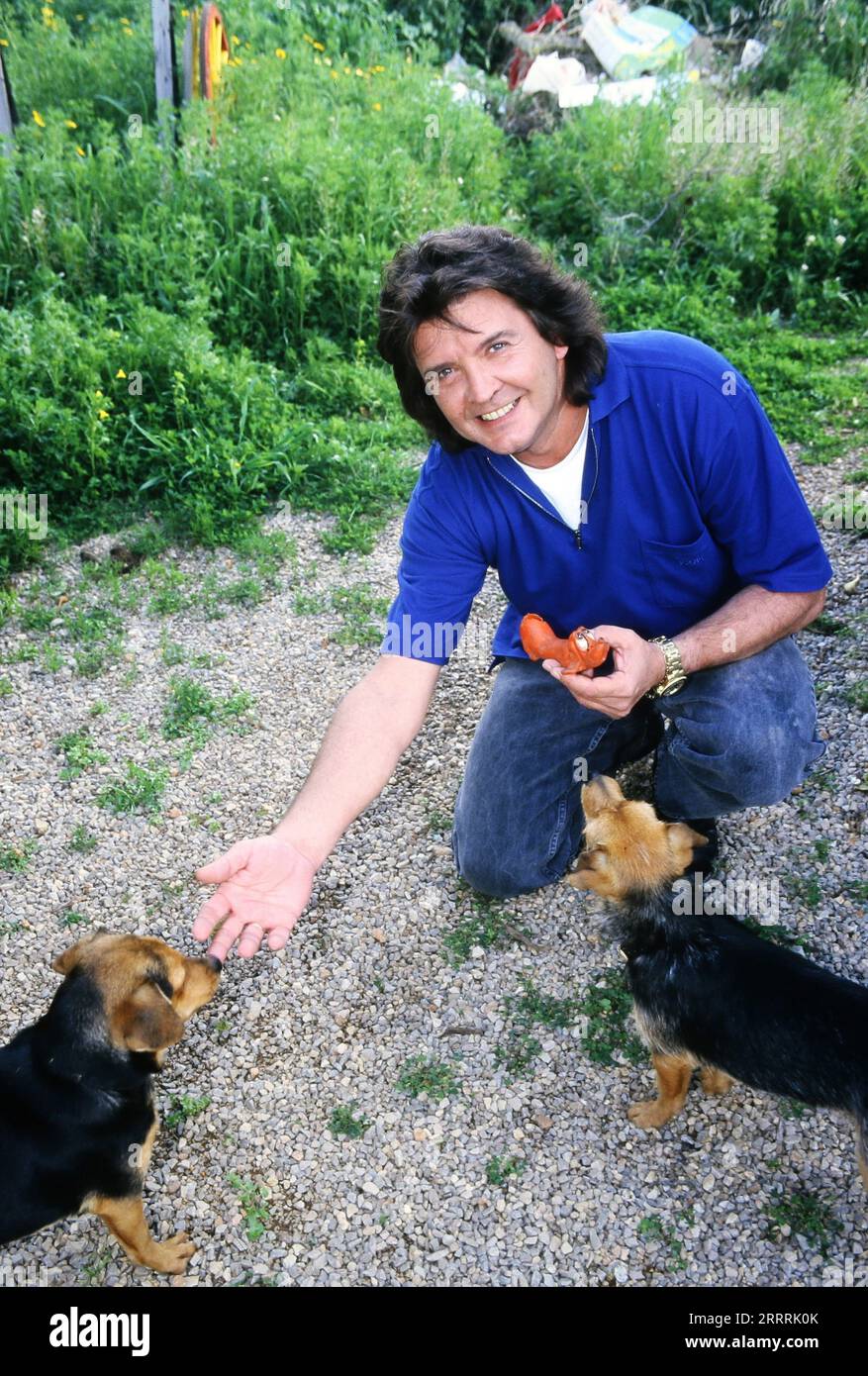 Bernd Clüver, deutscher Schlagersänger, füttert die Hunde zuhause auf Mallorca, Spanien 1998. Stock Photo