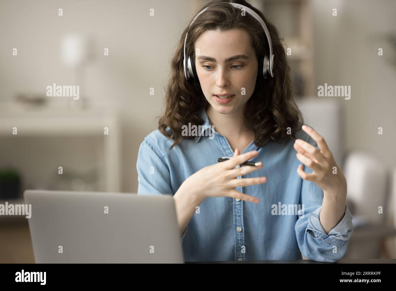 Serious gen Z student in headphones talking on video call Stock Photo ...