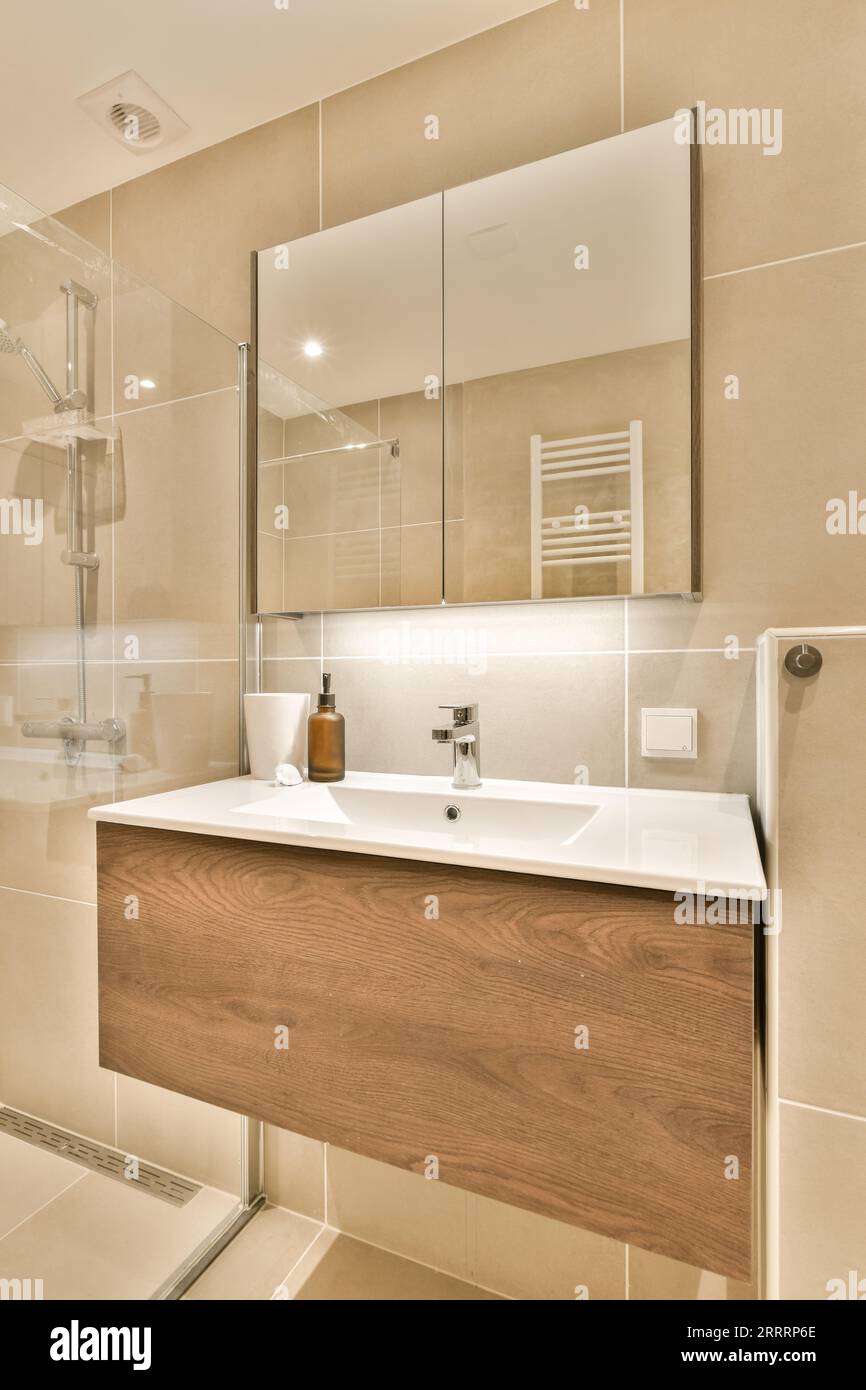 a bathroom with a sink, mirror and shower stall in the corner on 