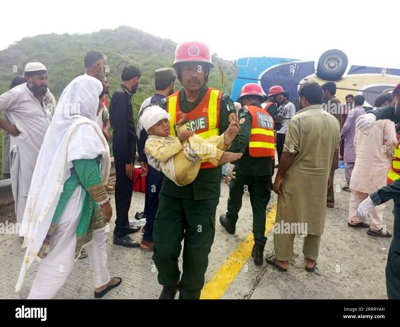 230618 -- CHAKWAL, June 18, 2023 -- A rescuer holds a child at a road accident site in Chakwal district of Pakistan s eastern Punjab province on June 17, 2023. At least 14 people were killed and over 20 others injured when a passenger bus turned turtle in Chakwal district of Pakistan s eastern Punjab province on Saturday, police officers said. The accident took place on the motorway near Kallar Kahar area of the district when the driver of the bus lost control of the vehicle due to brake failure, leading to the tragic crash, Deputy Inspector General of National Highways and Motorway Police Muh Stock Photo