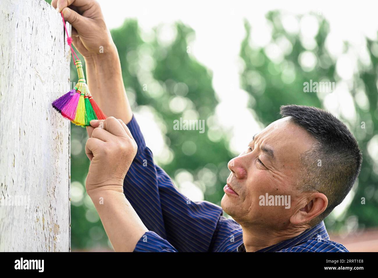230622 -- CHANGCHUN, June 22, 2023 -- Rong Fengming hangs a broom ...