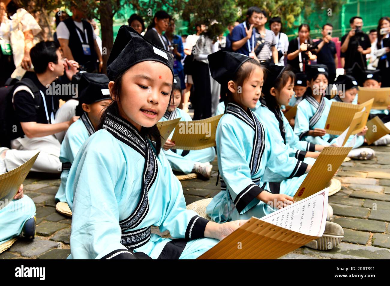 230627 -- QUFU, June 27, 2023 -- Children read the Analects of Confucius at the Confucius Temple in Qufu, east China s Shandong Province, June 27, 2023. A series of activities to promote traditional Chinese culture were held at the Confucius Temple in Qufu during the World Internet Conference Nishan Dialogue on Digital Civilization on Tuesday.  CHINA-SHANDONG-QUFU-WORLD INTERNET CONFERENCE-CULTURAL ACTIVITIES CN GuoxXulei PUBLICATIONxNOTxINxCHN Stock Photo