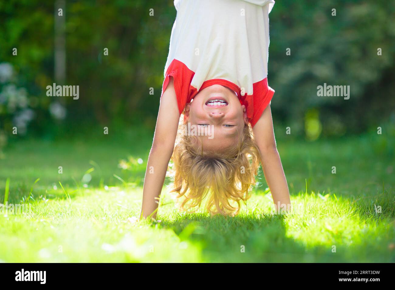 Little boy hanging upside down. Handstand exercise for little kids ...