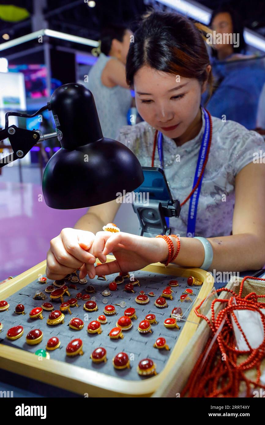 230629 -- CHENGDU, June 29, 2023 -- A staff member sells red agate