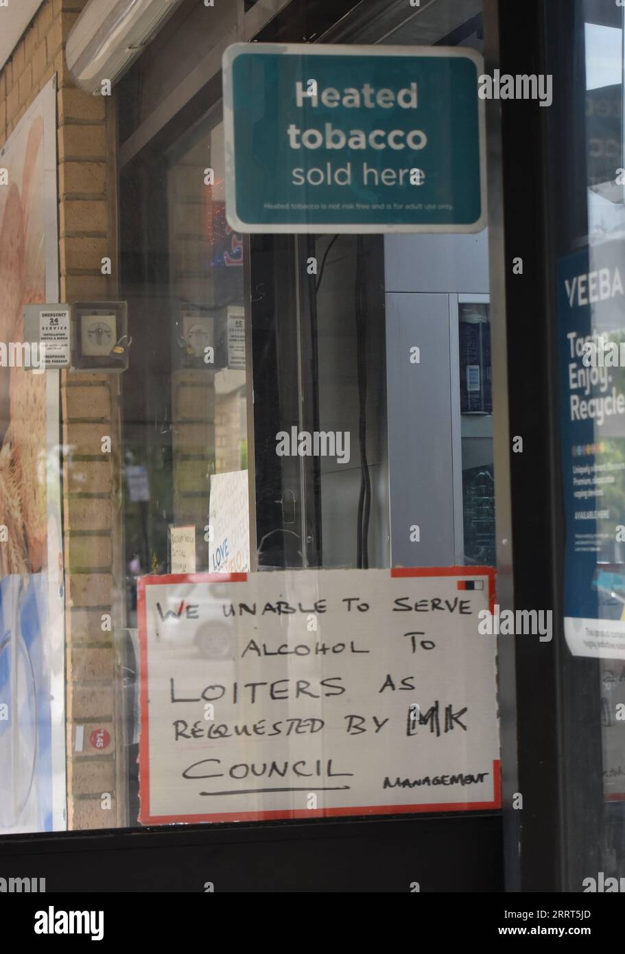 Sign on a shop door: 'We unable to serve alcohol to loiters as requested by MK Council'. Stock Photo