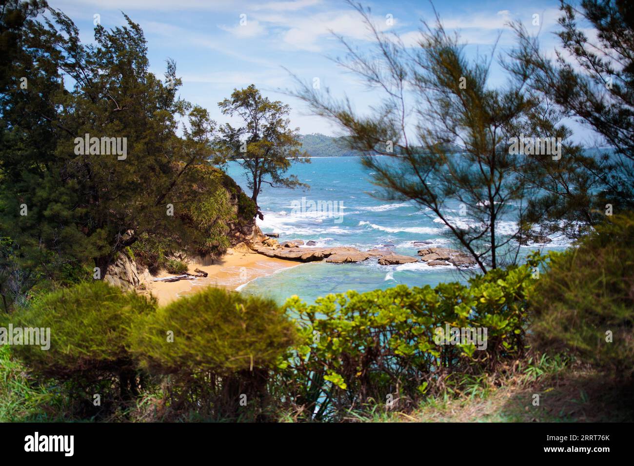 Scenic view of ocean bay from a hill. Hiking and travel. Tip of Borneo, East Malaysia. Visit Asia. Sea beach surrounded by rocks. Stock Photo