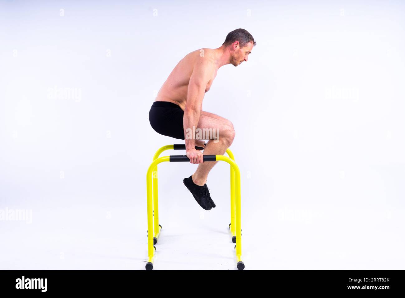 Strong man doing sports. Fitness on gorizontal and parallel bars. Pull