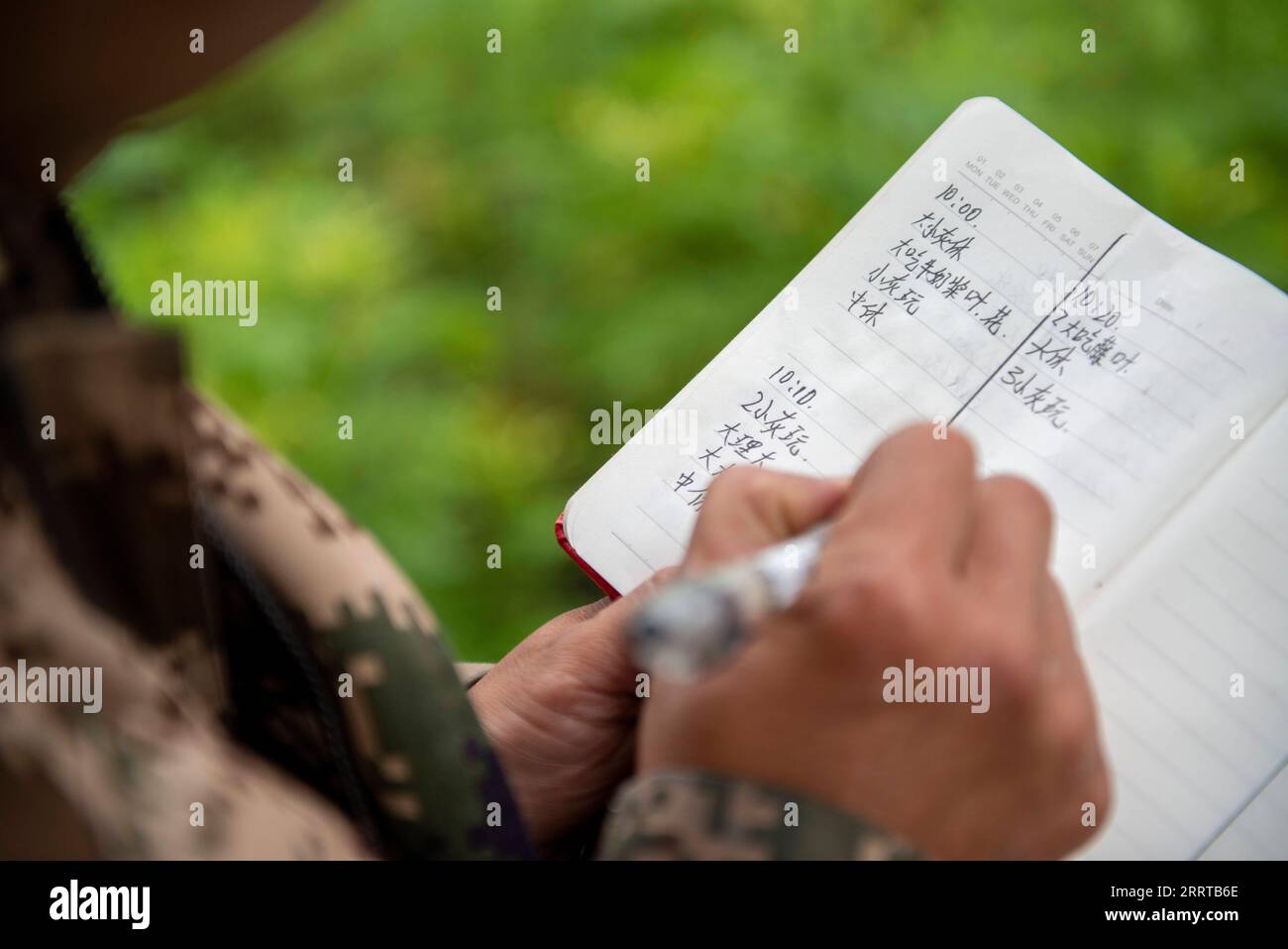 230712 -- LUSHUI, July 12, 2023 -- A ranger records the activity of ...