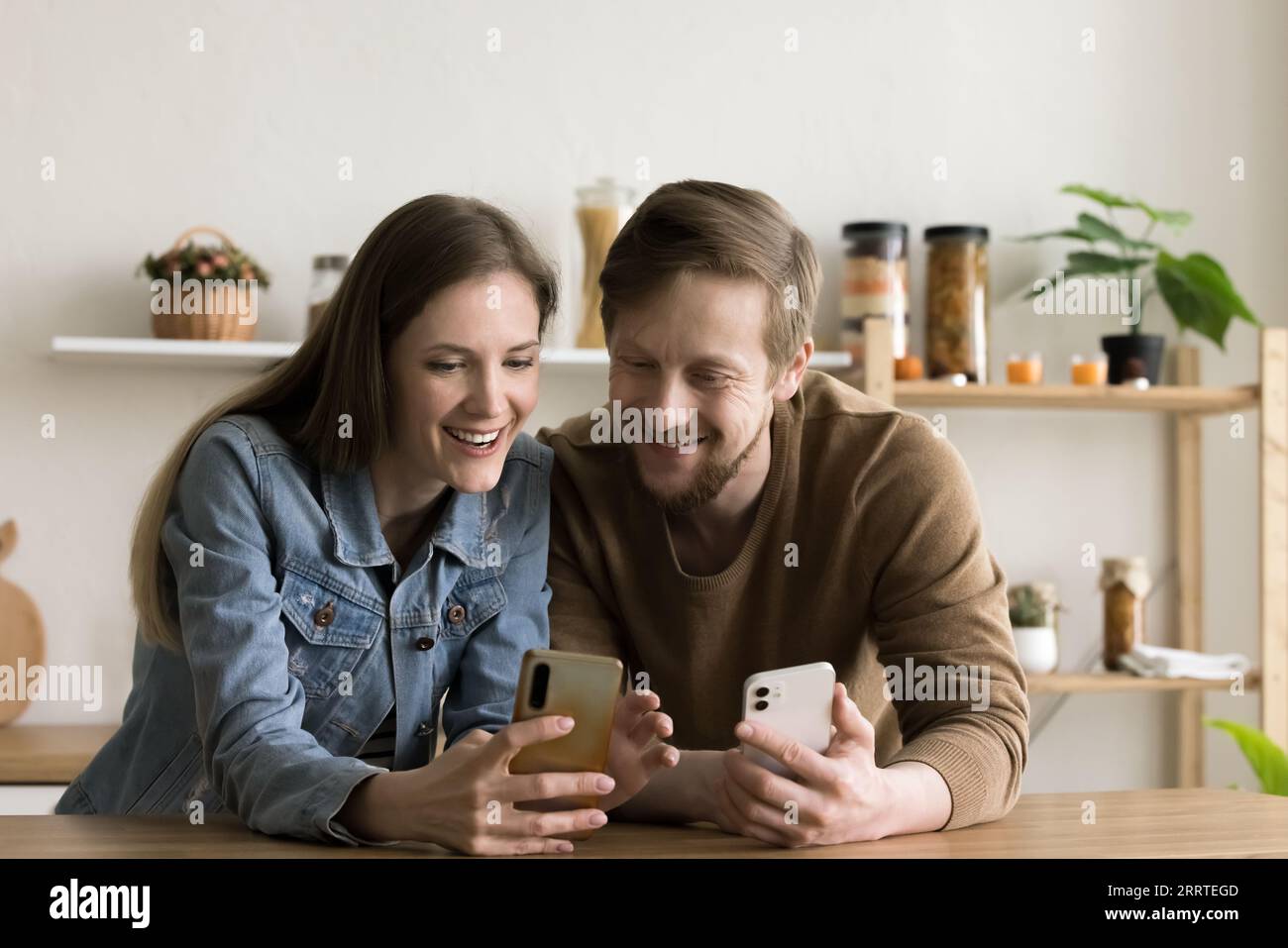 Happy young couple using Internet technologies on gadgets at home Stock Photo