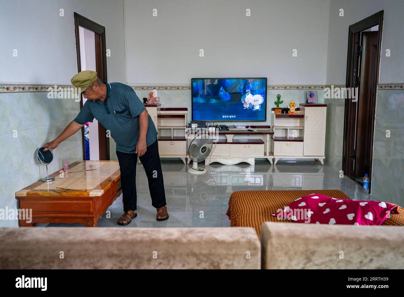 230726 -- JINPING, July 26, 2023 -- Zhang Puzhong does housekeeping in the sitting room of his residence before a tour to the forest in Xiaxinzhai Village, Zhemi Township, Jinping County, Honghe Hani and Yi Autonomous Prefecture, southwest China s Yunnan Province, July 23, 2023. After days of thinking, Zhang Puzhong decided to do something instructive to his grandchildren: bring them back to the forest he used to live as a child more than 60 years ago. This is very important. I know how happy I am today because I never forget how bitter my life was in the past, Zhang said. Zhang is a 70-year-o Stock Photo