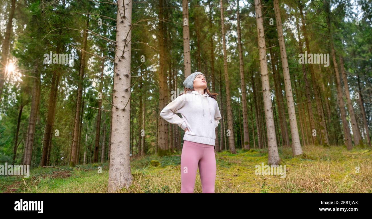 Fit, sporty woman stretching out before exercise outside in a forest, outdoor exercise concept Stock Photo