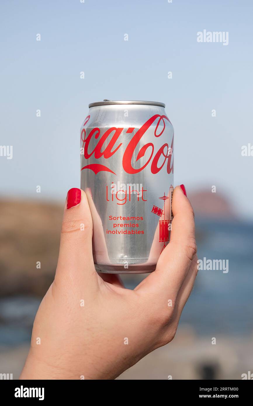 Woman holding in her hand a can of Coca-Cola Light, with the visible brand of the carbonated soft drink produced by The Coca-Cola Company Stock Photo