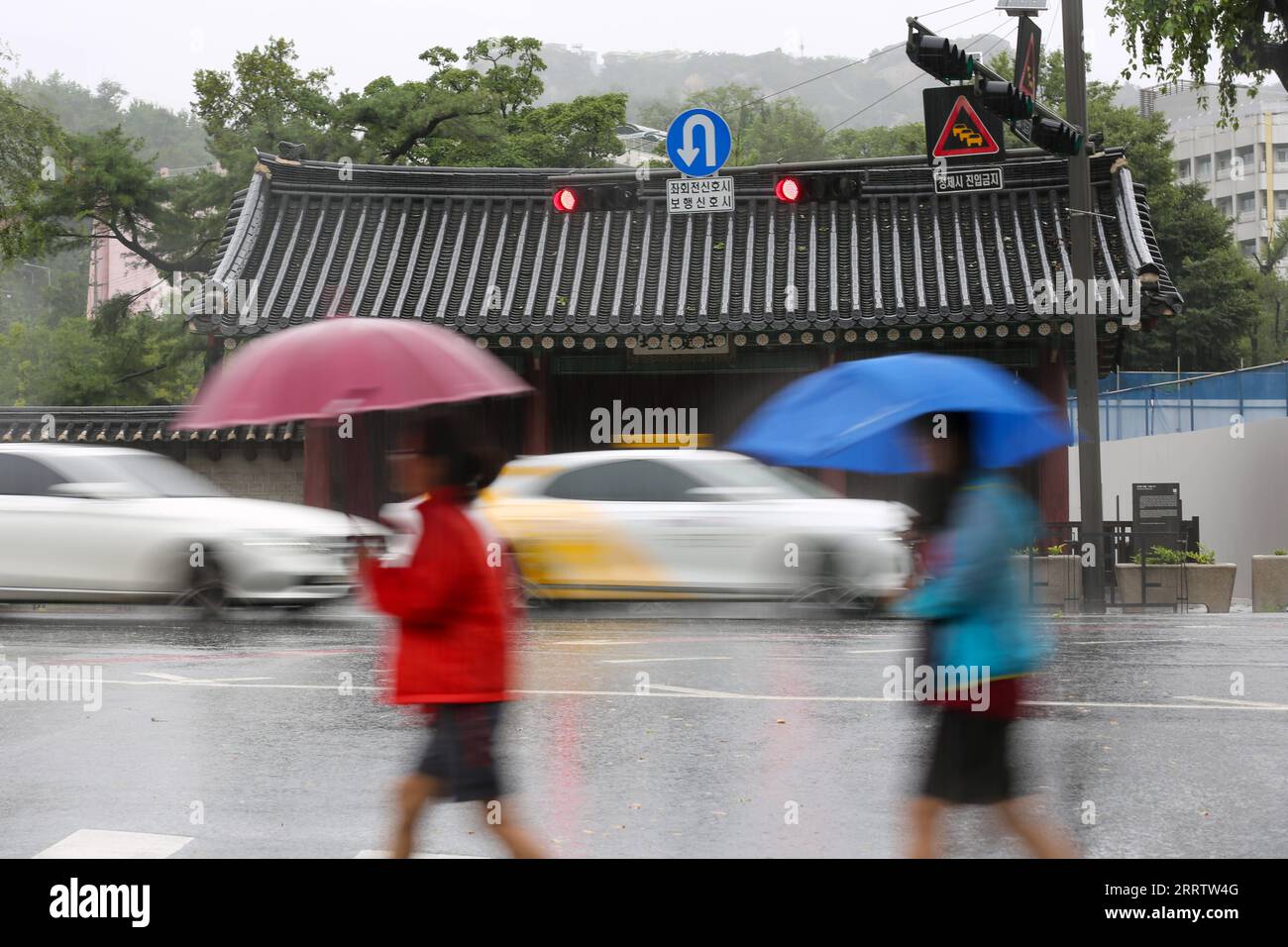 230810 SEOUL, Aug. 10, 2023 People walk on a street in the rain