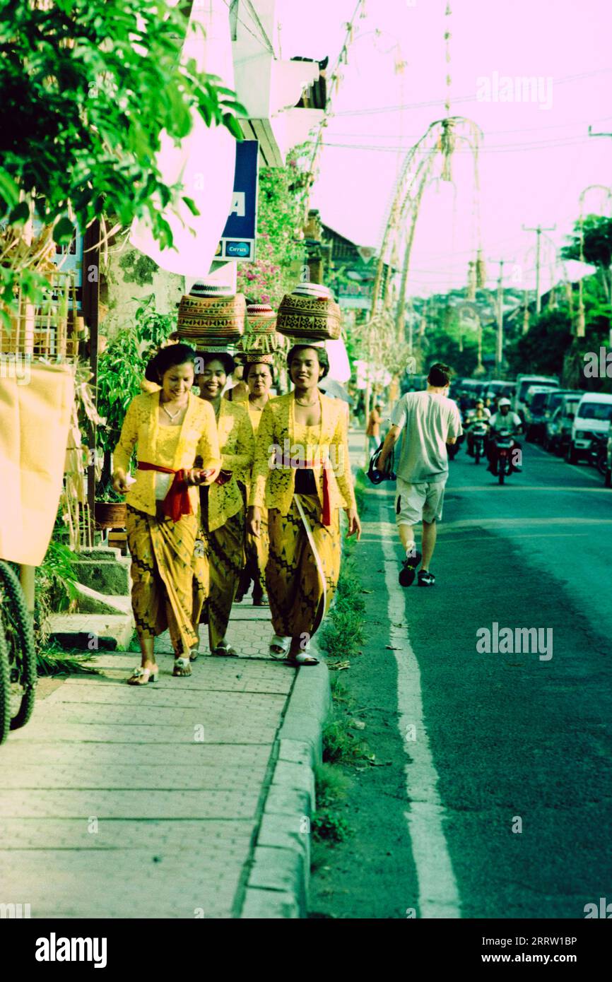 A group of Balinese women dressed in traditional clothing on their way to the temple Stock Photo