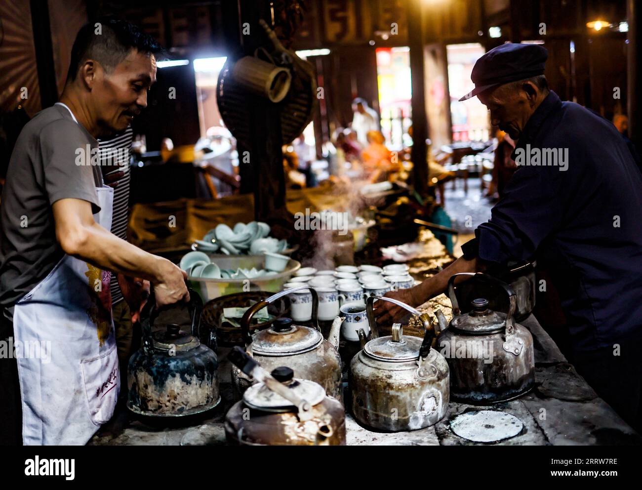 https://c8.alamy.com/comp/2RRW7RE/230815-chengdu-aug-15-2023-a-waiter-works-at-guanyinge-teahouse-in-shuangliu-district-of-chengdu-capital-of-southwest-china-s-sichuan-province-aug-7-2023-guanyinge-located-on-a-riverside-at-an-ancient-street-in-shuangliu-district-of-chengdu-is-a-teahouse-with-a-history-of-more-than-one-hundred-years-the-name-of-the-teahouse-guanyinge-originates-from-a-folk-tale-in-which-it-is-said-that-thanks-to-the-blessing-of-the-bodhisattva-avalokitesvara-guanyin-the-teahouse-survived-a-fire-a-hundred-years-ago-many-local-senior-citizens-enjoy-spending-their-time-at-guanyinge-teahouse-2RRW7RE.jpg